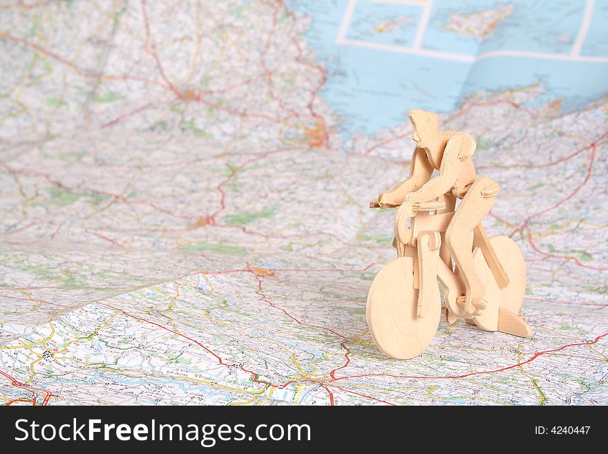 Wooden model of bicyclist on background of map. Wooden model of bicyclist on background of map