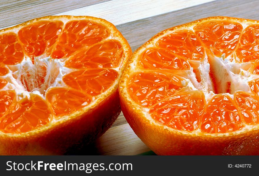 Fresh mandarin orange cutted in half on a wood cutting board. Fresh mandarin orange cutted in half on a wood cutting board