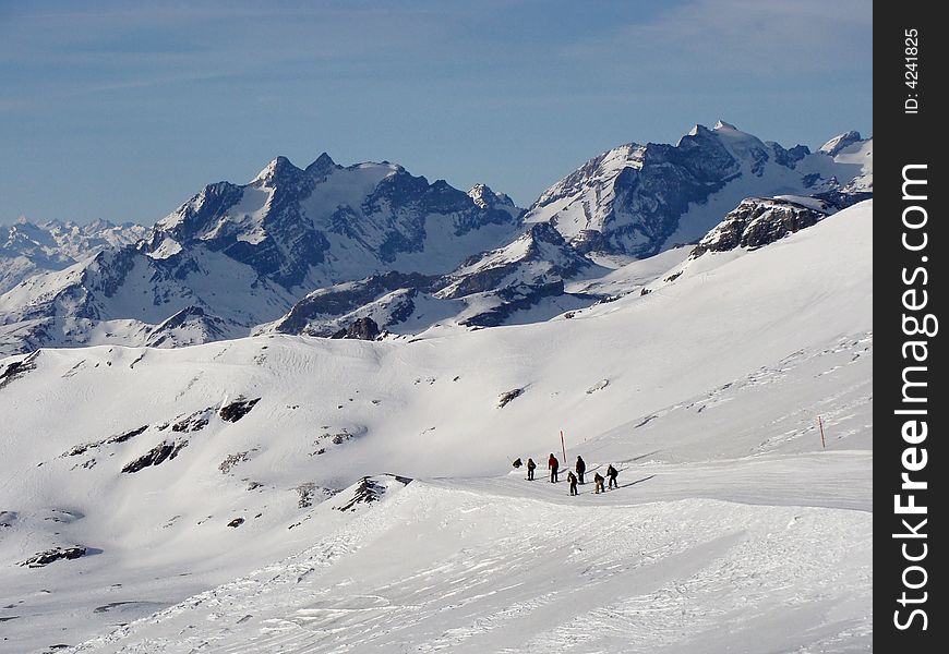 Ski run between rugged rocky mountains in the ski area of Flims Laax in the east of Switzerland. The mountains in the background are named Hausstock 3158 m / 10360 ft. and Bifertenstock 3421 m / 11224 ft. Ski run between rugged rocky mountains in the ski area of Flims Laax in the east of Switzerland. The mountains in the background are named Hausstock 3158 m / 10360 ft. and Bifertenstock 3421 m / 11224 ft.