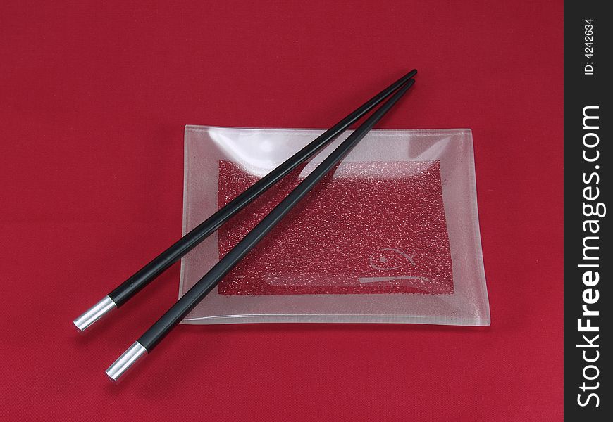 Chopsticks for a sushi on a red background
