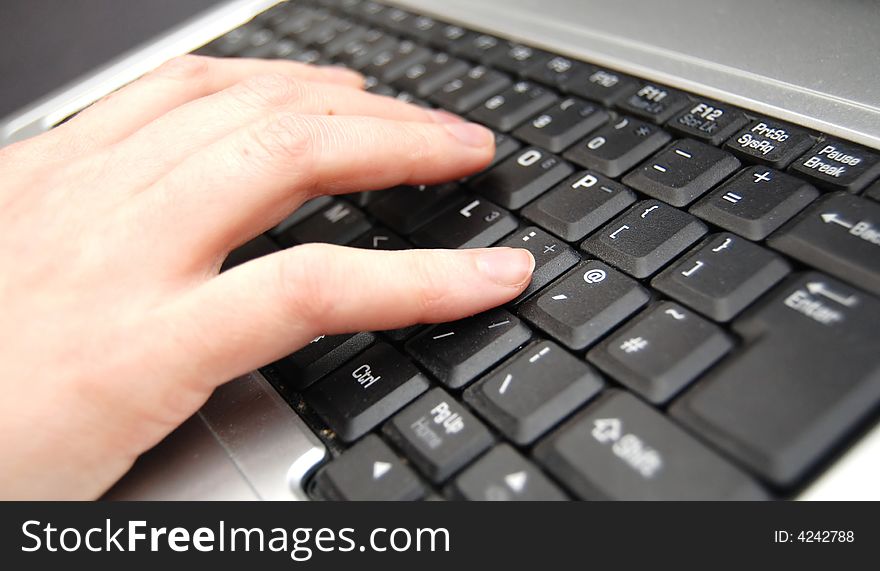 Hand typing on a black keyboard. Hand typing on a black keyboard