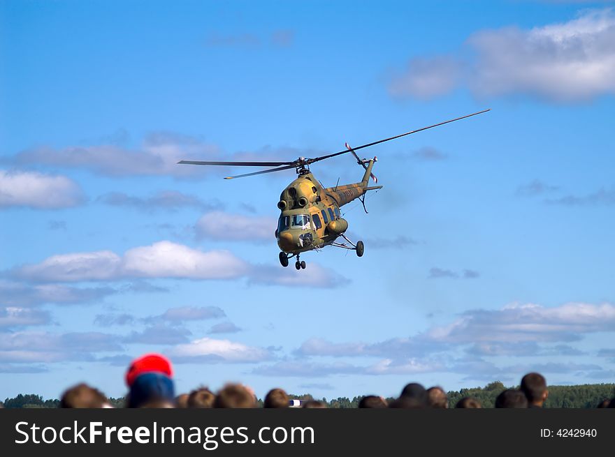 Helicopter flying above the people. Helicopter flying above the people