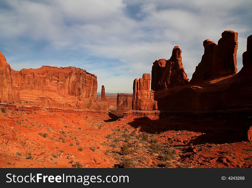View of the red rock formations in Arches National Park with blue skyï¿½s and clouds. View of the red rock formations in Arches National Park with blue skyï¿½s and clouds