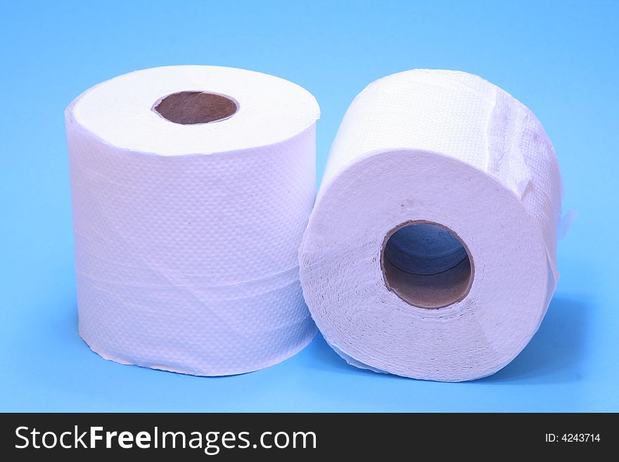 Two white toilet rolls on a bright blue background. Two white toilet rolls on a bright blue background.