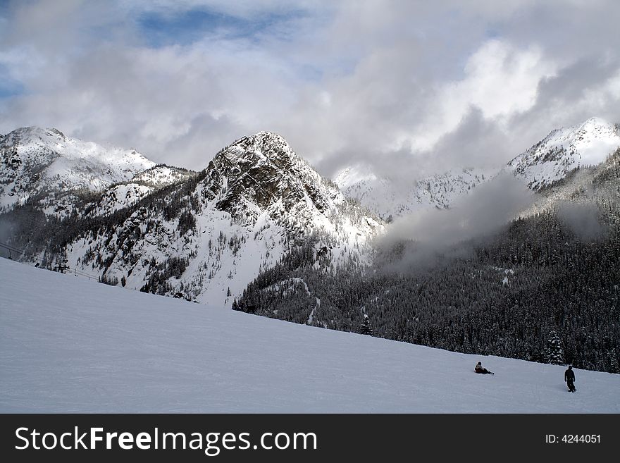 A pair of skiers take in the view on the slopes. A pair of skiers take in the view on the slopes.