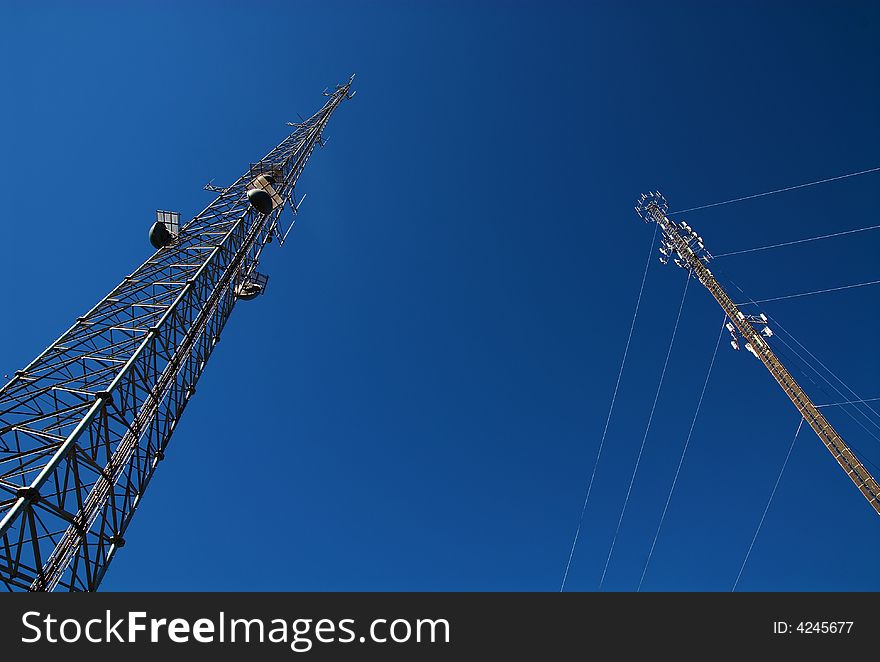 Cell towers with a deep blue sky behind them. Cell towers with a deep blue sky behind them.