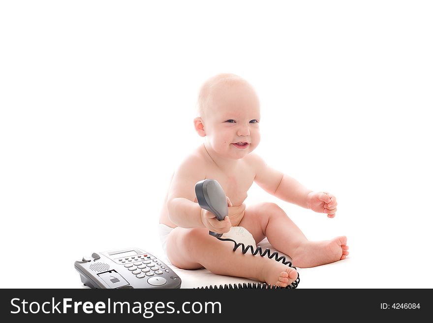 Little smiling baby with telephone receiver in hand over white background