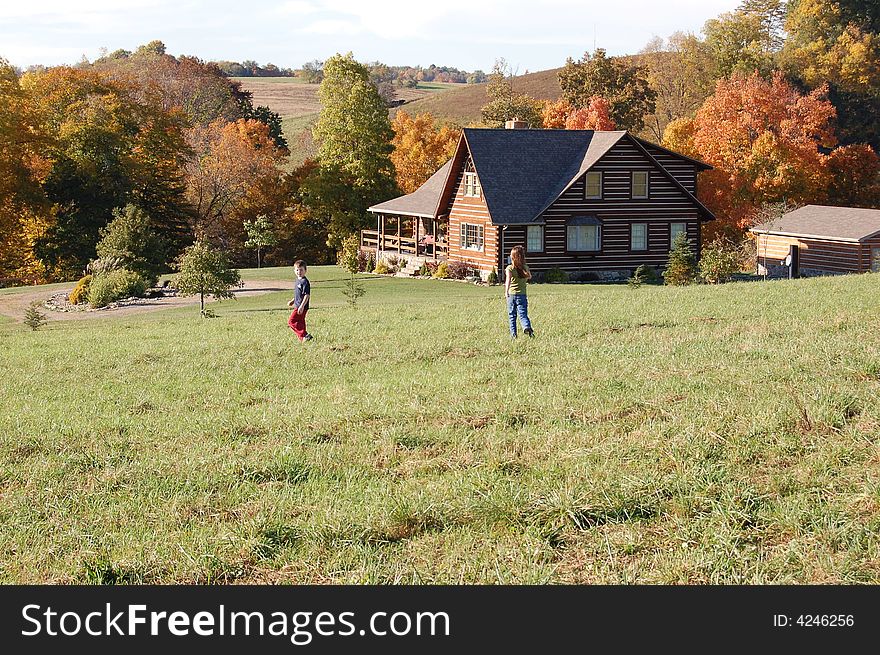 Log home in the fall with children walking home. Log home in the fall with children walking home.