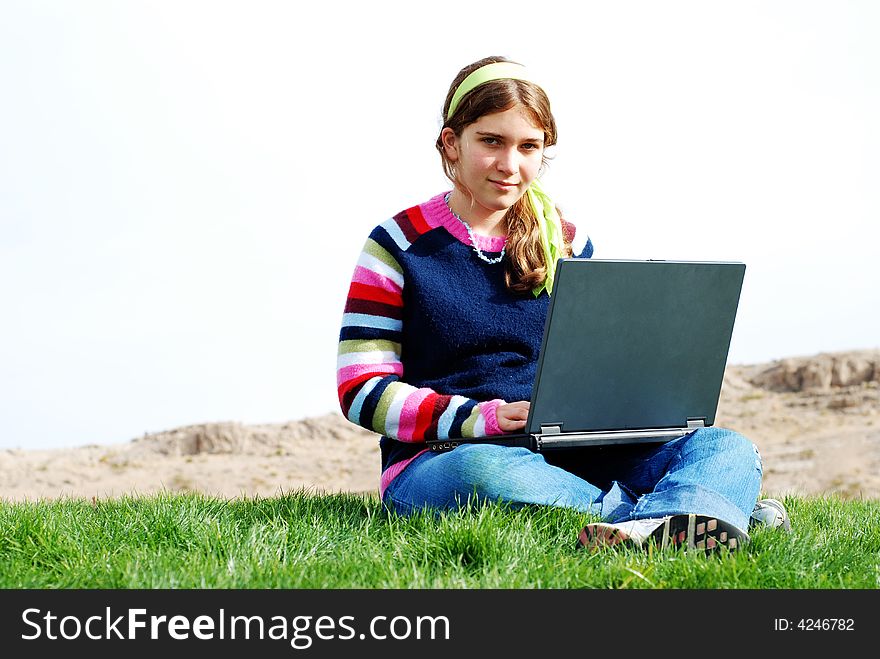 Young girl is working on laptop at outdoor location. Young girl is working on laptop at outdoor location