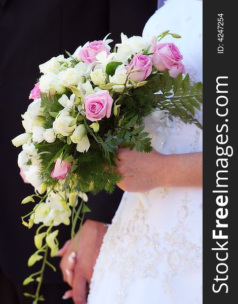 A bride with her bouquet in one hand, grooms hand in the other. A bride with her bouquet in one hand, grooms hand in the other.