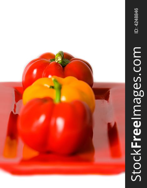 Macro of Bellpeppers on a red plate on a white background. Macro of Bellpeppers on a red plate on a white background.