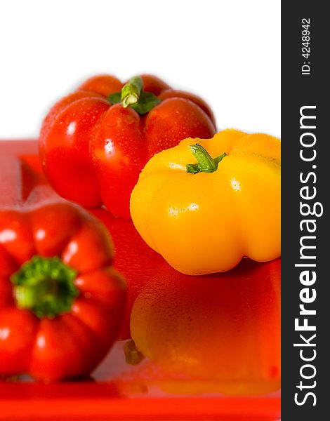 Bellpeppers on a red serving dish with a white background. Bellpeppers on a red serving dish with a white background.