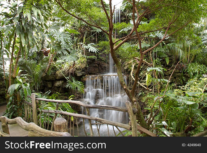 Beautiful sparkling waterfall surrounded with tropical plants. Beautiful sparkling waterfall surrounded with tropical plants
