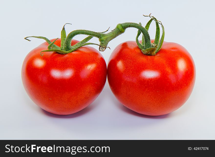 Two tomatos isolated on white background