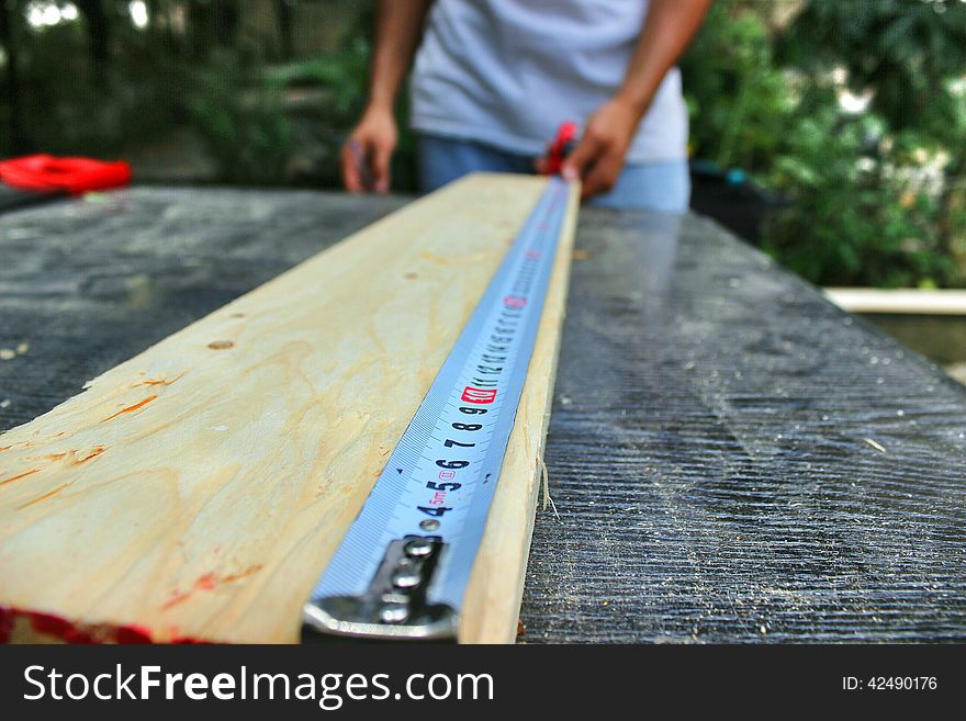 A hard tape used for measuring a wood plank. A hard tape used for measuring a wood plank.