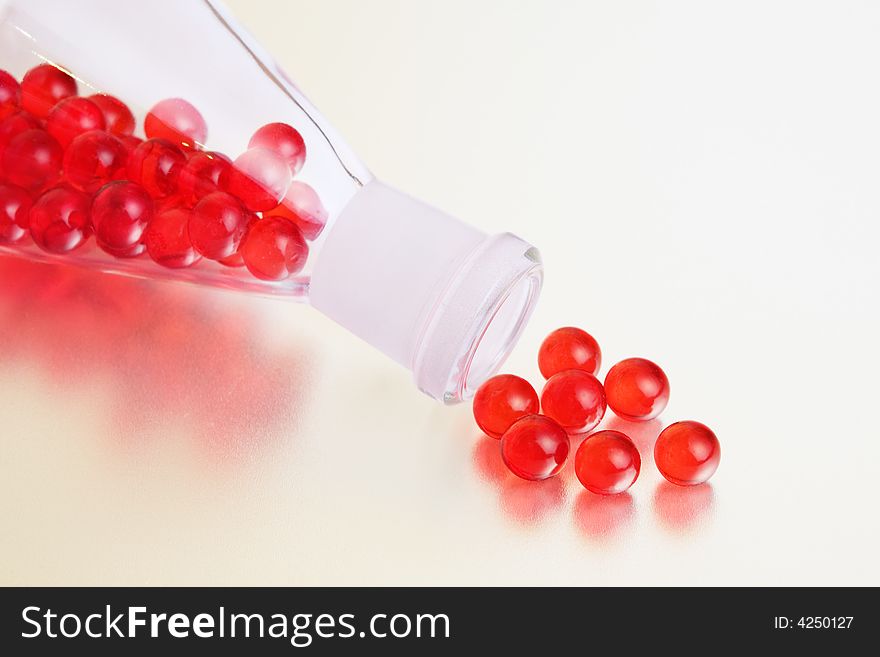 Red pills in a conical flask and and near to it with reflection. Red pills in a conical flask and and near to it with reflection