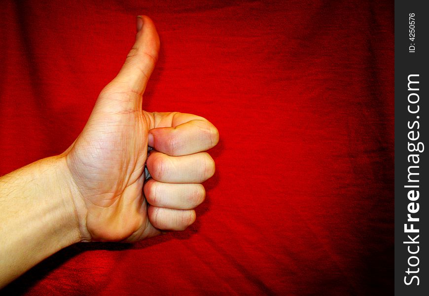 Hand showing success sign over red background