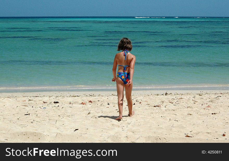 Girl Walking To The Sea On A Tropical Beach