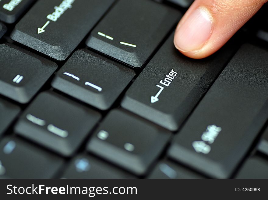 Close up of a male finger pressing enter on a keyboard. Close up of a male finger pressing enter on a keyboard