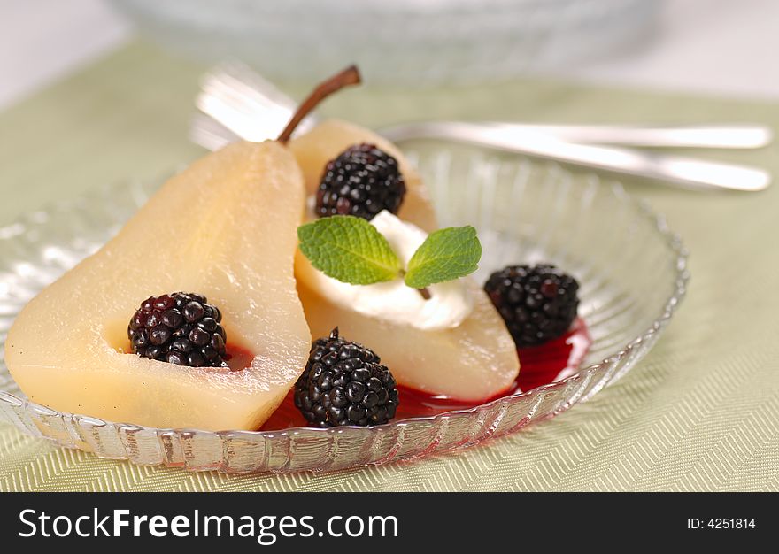 Pear poached in white wine with blackberry sauce