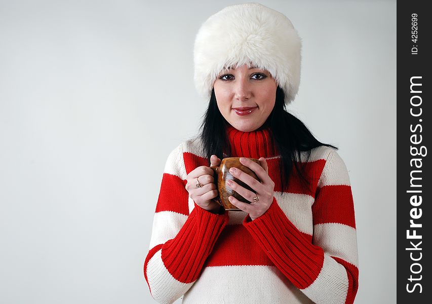 Winter portrait of young beautiful girl in fluffy hat with hot cup. Winter portrait of young beautiful girl in fluffy hat with hot cup