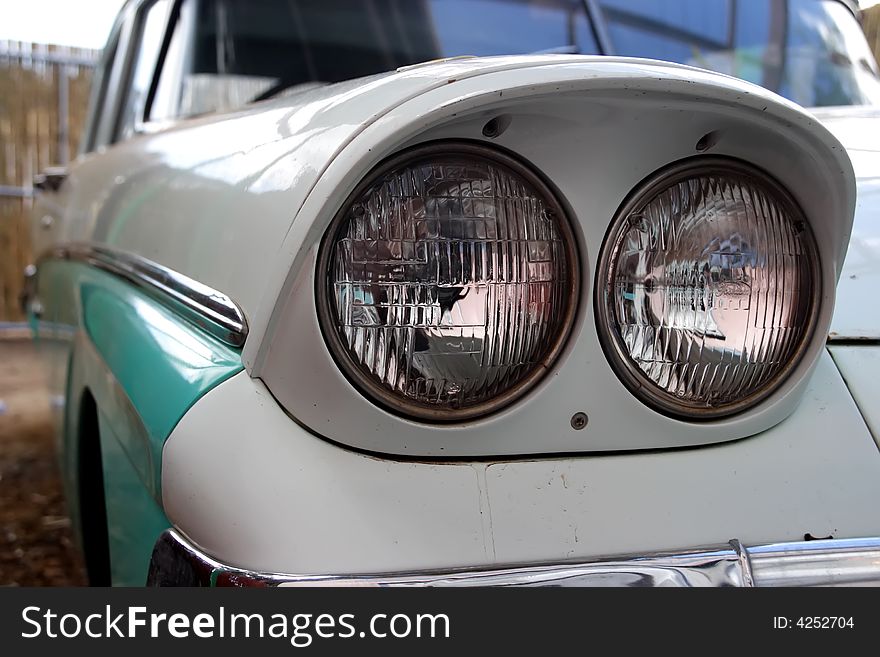 Headlights of an old white and green automobile. Headlights of an old white and green automobile