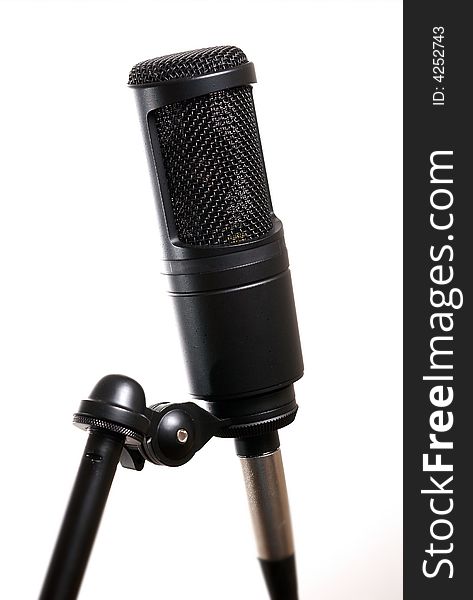 A black condenser microphone on white background. A black condenser microphone on white background.