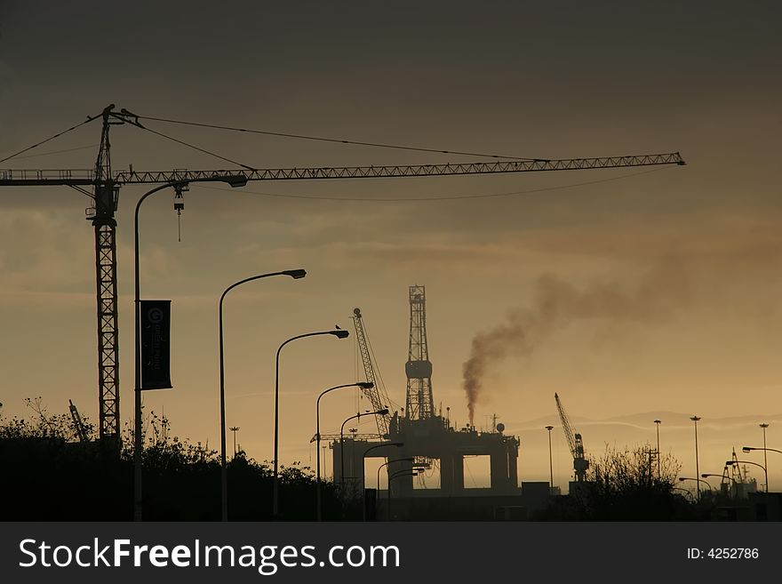 A silhouette of a oil rig and a crane. A silhouette of a oil rig and a crane