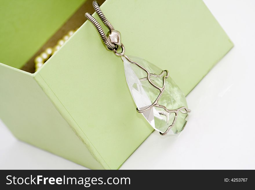 Green gift box with diamond necklace on white