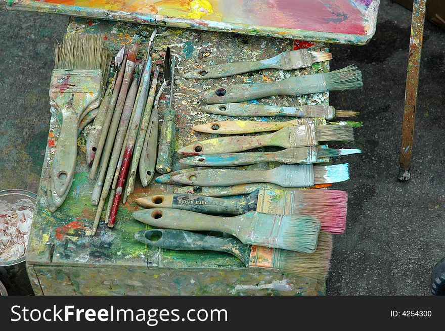 Artist paint palette with paints and brushes