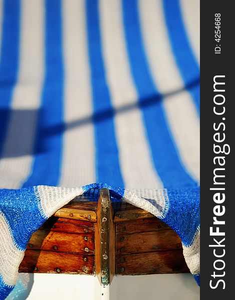 Boat with a white-blue cover and a wooden tip. Boat with a white-blue cover and a wooden tip