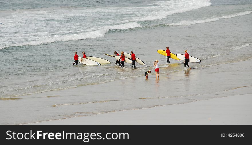 A family going surfing with red top wet suit. A family going surfing with red top wet suit