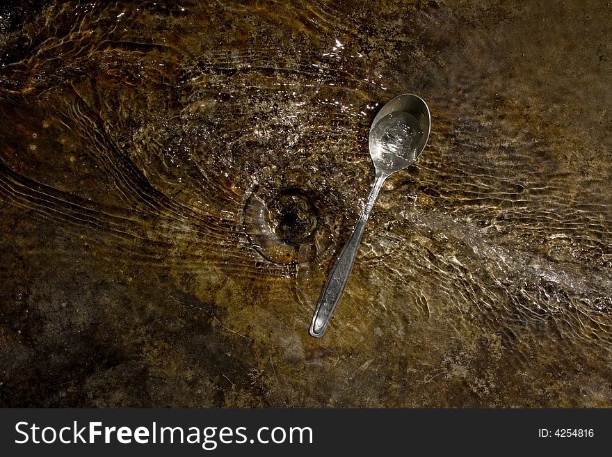 The old bowl, rusty, flows water, a drain
At the bottom the aluminium spoon, is a lot of water