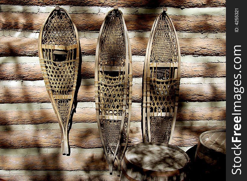 Snowshoes hanging on log cabin wall
