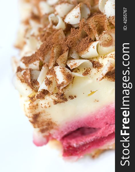 A slice of raspberry cheesecake with white chocolate shavings and chocolate dust toppings. A slice of raspberry cheesecake with white chocolate shavings and chocolate dust toppings