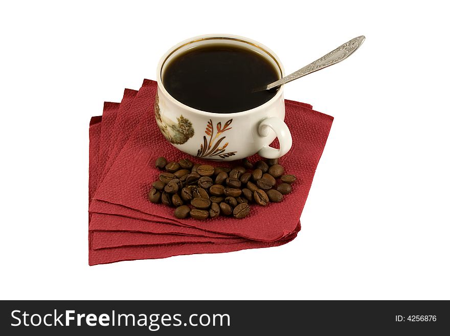 An isolated cup of hot coffee on a red napkin with some coffee-beans. An isolated cup of hot coffee on a red napkin with some coffee-beans