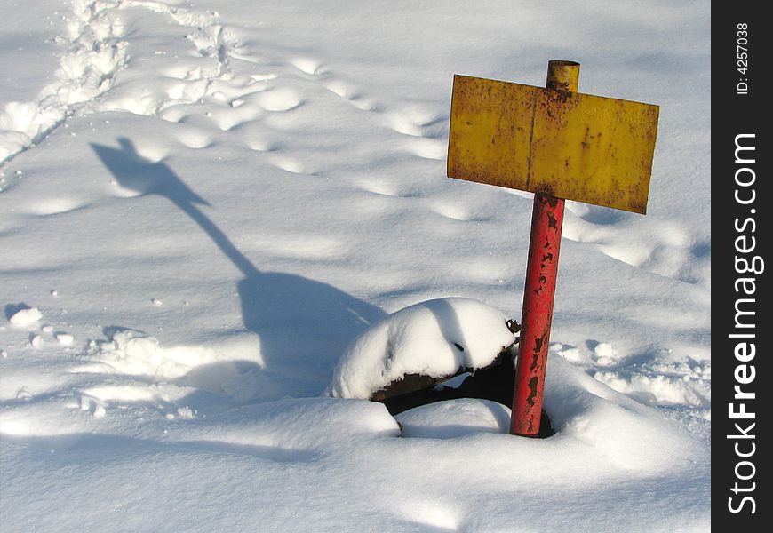 Yellow rusty tablet with shadow on snow. Yellow rusty tablet with shadow on snow