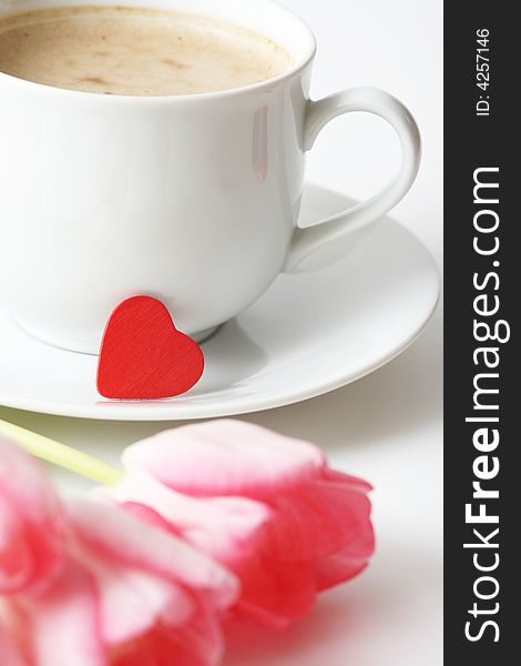 Coffee cupwith coffee,small red heart and pink tulip. Coffee cupwith coffee,small red heart and pink tulip.