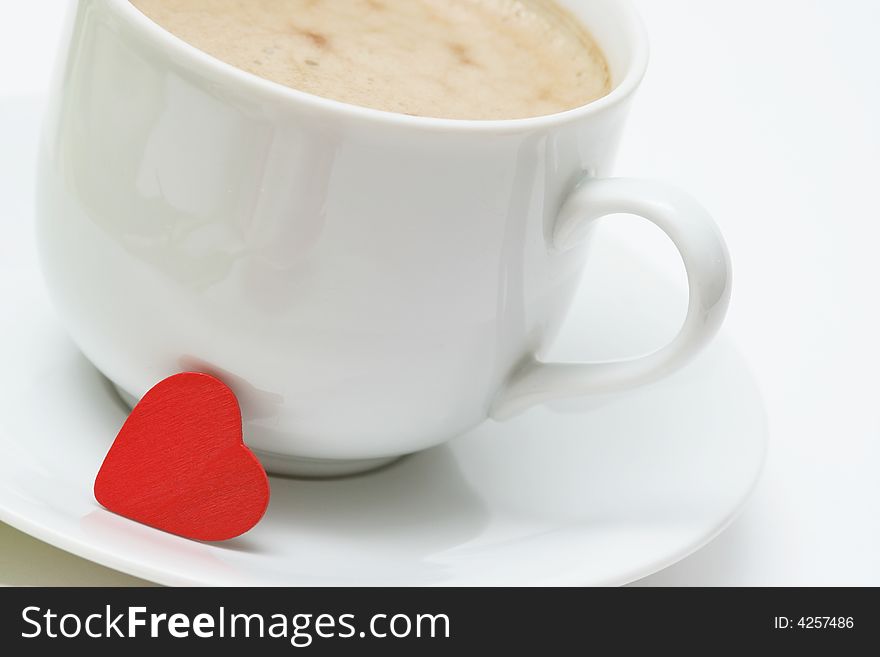 Coffee cup with coffee and small red heart on white background. Coffee cup with coffee and small red heart on white background.