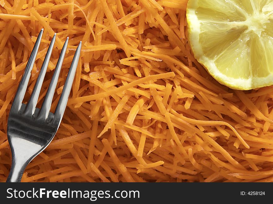 Julienne shredded carrots salade with lemon and fork. Julienne shredded carrots salade with lemon and fork