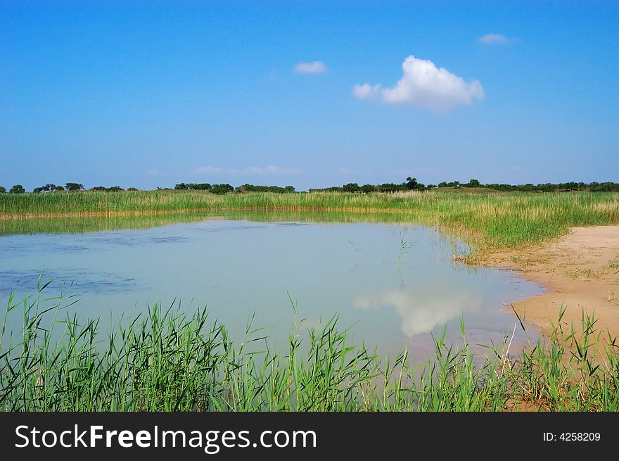 Light cloud in blue sky， inverted reflection in lake water. Light cloud in blue sky， inverted reflection in lake water