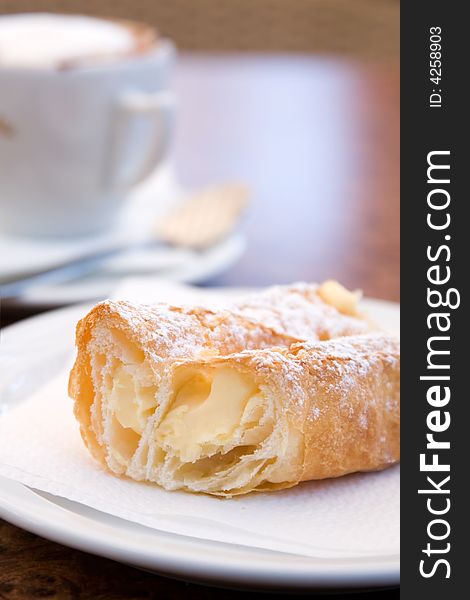 Cappuccino and delicious pastry on cafe table