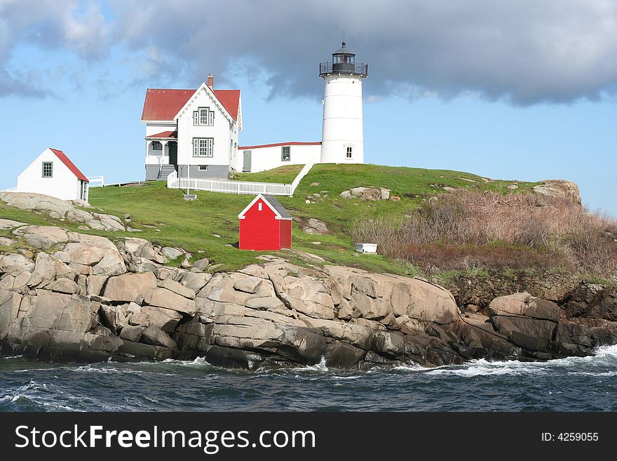 Lighthouse on the coast of Maine,USA.
Showing ocean, rocks,and out-buildings with blue sky & stormy clouds. Lighthouse on the coast of Maine,USA.
Showing ocean, rocks,and out-buildings with blue sky & stormy clouds.