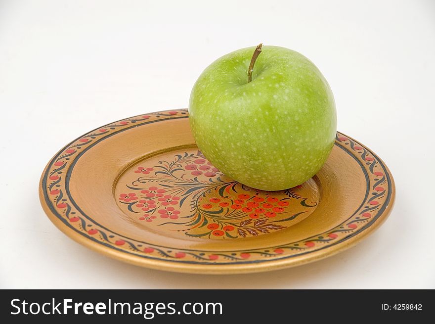 Green apple on a colour wooden plate. Green apple on a colour wooden plate.