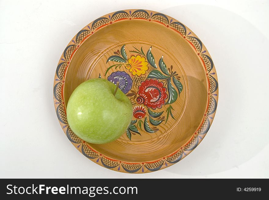 Green apple on a colour wooden plate. Green apple on a colour wooden plate.