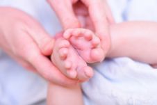 Mother Hold Baby Leg In Hand Royalty Free Stock Photography