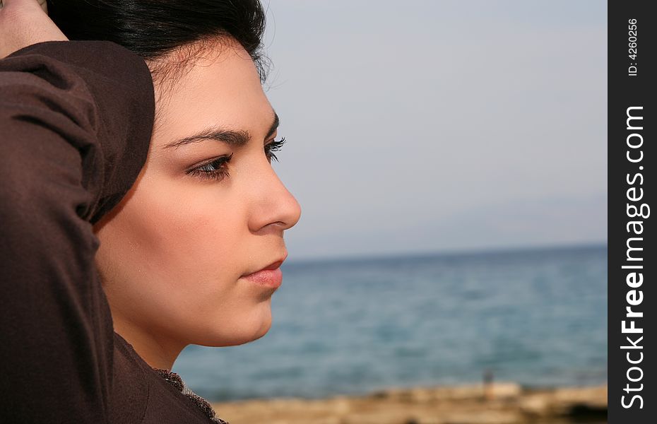 A young brunette woman portrait at the beach. A young brunette woman portrait at the beach