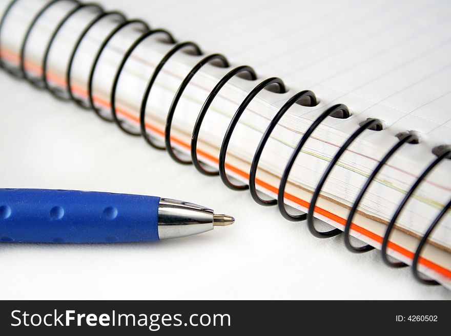 close up of a spiral notebook and pen isolated on white. close up of a spiral notebook and pen isolated on white.