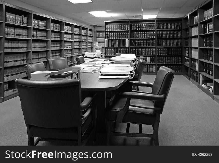 Conference room table with several leather chairs and shelves of books. Conference room table with several leather chairs and shelves of books