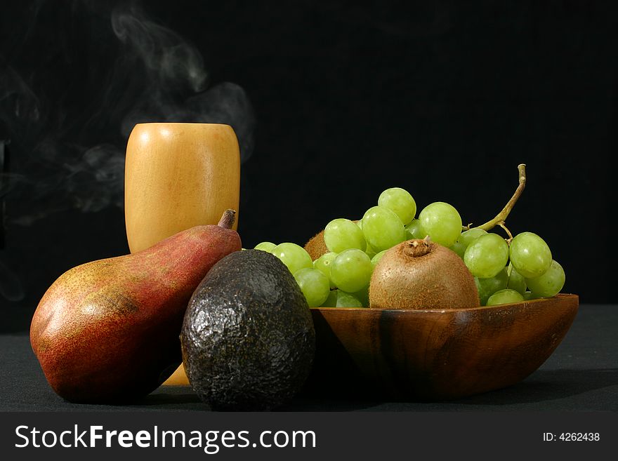 Arrangement of fruit with pear, grapes, kiwi, and others with wooden cup. Arrangement of fruit with pear, grapes, kiwi, and others with wooden cup